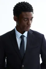 Blazer slim fit negro de botonadura sencilla, con solapas de muesca finas, bolsillos con solapa y abertura doble en la parte trasera.