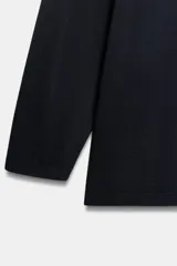 Jersey de punto fino con diseño oversize, cuello redondo y manga larga.