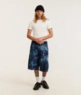 Bermuda baggy relaxed de jeans color azul, con estampa manchada, cintura con trabillas, cierre tradicional y bolsillos.