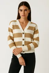 Cardigan de punto con cuello en V, manga larga y cierre frontal de botones. Presenta un diseño de rayas horizontales anchas en color beige y blanco crudo.