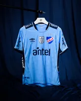 Camiseta de fútbol Umbro del Club Nacional de Football, edición especial de color celeste con detalles en azul marino y blanco. Incluye el escudo del club bordado con tres copas arriba, logo de Umbro, y sponsors BBVA y Antel.