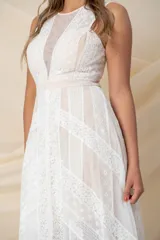 Vestido largo de tul color nude con apliques de encaje blanco y corte irregular.