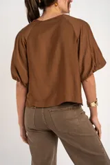 Blusa marrón de mangas cortas abullonadas, cuello redondo y diseño holgado.
