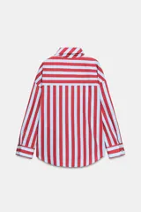 Camisa de manga larga con cuello subido y detalle de lazada frontal. Presenta un diseño de rayas verticales en tonos verde y celeste, con cierre frontal de botones y puños clásicos.