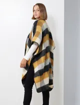 Ruana de tejido soft, marca Barrington, con diseño a cuadros grandes en tonos mostaza, gris oscuro y blanco. Presenta terminación en zig zag con lana en los bordes.