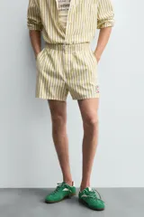 Shorts de hombre confeccionados en algodón con estampado de rayas verticales amarillas y blancas. Presenta cintura elástica, bolsillos frontales y un pequeño bordado de un pez en la parte inferior derecha.