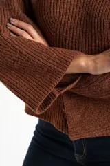 Polera de lana color marrón, con cuello alto, diseño acanalado y corte oversize con mangas anchas.