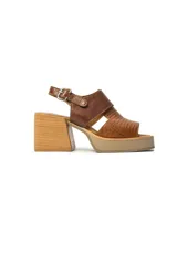 Sandalias de plataforma con taco cuadrado, confeccionadas en cuero con combinación de texturas lisa y grabada en tonos marrones. Presentan una tira ajustable con hebilla metálica en el tobillo.