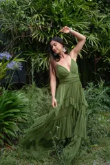 Vestido largo de tul color verde oliva, con escote en V pronunciado, tirantes finos y falda amplia con volados en niveles.