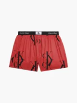 Boxer de algodón con estampado repetido del logo 'CK' en negro sobre fondo rojo. Cintura elástica negra con el logo 'Calvin Klein' en blanco.