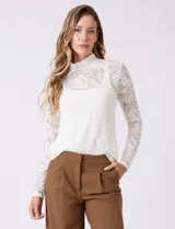 Blusa de encaje color blanco con cuello alto y mangas largas. Incluye musculosa interna a tono para mayor cobertura.