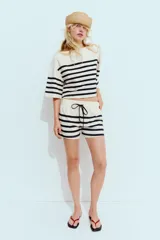 Shorts de tiro alto y cintura elástica ajustable con cordones a contraste, con bolsillos laterales ocultos en la costura.