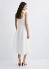 Vestido midi color blanco de lino, sin mangas, con escote cuadrado, corte en la cintura y falda evasé con bolsillos laterales.