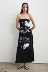 Vestido largo negro de algodón sin tirantes con escote palabra de honor, estampado de rosas blancas y aberturas laterales.