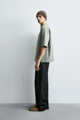 Sudadera de corte boxy fit, color verde oliva con efecto lavado. Presenta cuello redondo, manga corta terminada en rib y textos estampados a contraste en color rojo en el pecho.