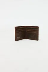Billetera combinada en cuero marrón con costuras decorativas y pequeño aplique metálico de estrella y líneas en el frente. Interior con compartimentos y forro de algodón.
