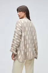 Saco abierto de tejido de punto en color marrón con diseño de rayas verticales abstractas en tono beige. Presenta mangas tres cuartos y un corte holgado.