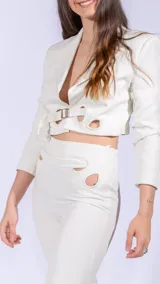 Pantalón de vestir blanco acampanado con aberturas circulares en la cintura.