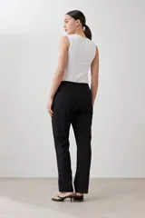 Pantalón de corte recto en color beige, con cintura media y cierre frontal oculto. Presenta un diseño limpio y minimalista con bolsillos laterales.