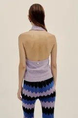 Pantalón tejido con diseño de ondas en tres colores, lila, azul y negro. Presenta pequeños calados en líneas verticales y cintura elastizada.