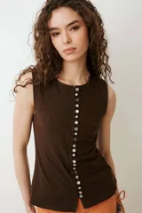 Musculosa turquesa de algodón con escote redondo y cierre frontal decorado con una hilera de múltiples botones vintage variados.