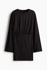 Vestido corto de manga larga confeccionado en punto elástico de color negro, con escote redondo, cuerpo holgado y falda entallada.