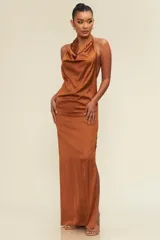 Vestido largo de satén con escote drapeado y espalda descubierta. Presenta un corte fluido y elegante con una abertura lateral en la falda.