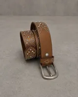Cinturón de cuero color tostado con diseño decorativo de tachas metálicas y cristales brillantes. Incluye hebilla metálica clásica y presilla con detalle de tachas.
