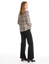 Blusa de seda fría con estampado geométrico tipo ikat en tonos beige y negro. Presenta escote en V, botones decorativos en la parte frontal y mangas tres cuartos con detalle de tajo en los puños.