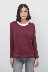 Remera de manga larga color bordó con cuello redondo en contraste color crema y costuras decorativas visibles en el ruedo y puños.