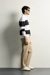 Pantalón regular fit de hombre color negro, confeccionado en tejido técnico ligero con cintura elástica, bolsillos frontales, bolsillos traseros de vivo y cierre frontal con cremallera y botón.