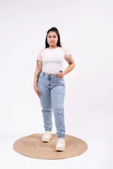 Remera tipo baby tee ajustada al cuerpo, color blanco con mangas cortas estilo raglán en color rosado. Presenta estampado frontal con texto en tonos rosados.