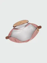 Mochila Longchamp modelo Le Pliage Original en tamaño M, color rosado con solapa y detalles en cuero marrón. Cuenta con correas ajustables de tela y cierre superior con solapa de botón a presión.