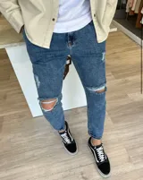 Pantalón de jean azul oscuro con roturas en las rodillas y diseño slouchy de corte holgado.