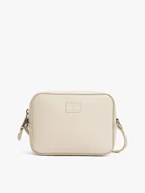 Bandolera Tommy Jeans color crema con logo tonal en el frente, correa ajustable y cierre de cremallera.