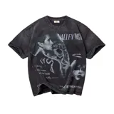 Camiseta de algodón color negro con efecto lavado, de corte oversize y manga corta. Presenta un estampado gráfico frontal con estética vintage, que incluye rostros y texto decorativo.
