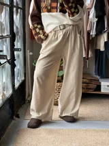 Pantalón de pana fina color beige, con cintura elástica y bolsillos laterales, de corte amplio y holgado.