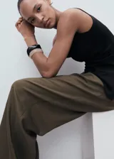 Top sin mangas de tejido de punto fino, con cuello drapeado y bajo asimétrico. Presenta un diseño entallado con tirantes anchos.