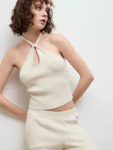 Top de punto acanalado color negro, con diseño de cuello halter y abertura frontal tipo gota.