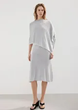 Poncho gris de punto con diseño asimétrico de capa, cuello barco y mangas tres cuartos.