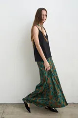 Musculosa de seda color negro, con escote en V y tirantes anchos, de corte fluido y suelto.