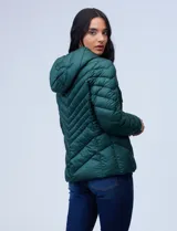 Campera de abrigo verde esmeralda, marca Michael Kors. Diseño acolchado con cierre metálico central, capucha no desmontable con cordón de ajuste y bolsillos verticales delanteros. Incluye bolsa autoportante.
