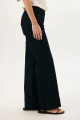 Pantalón de jean azul oscuro, de corte acampanado, con bolsillos delanteros y traseros, y costuras verticales en el frente.