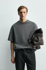 Sudadera de corte relajado confeccionada en tejido técnico interlock con mezcla de algodón, cuello redondo y manga corta.