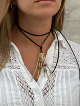 Gargantilla de cuero negro con colgante dorado en forma de rama con detalles de piedras de colores.