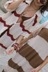 Camisa de tejido de punto color crudo, con diseño de rayas en zigzag en tonos terracota, azul claro y bordó. Presenta un calce oversize y cierre frontal con botones.