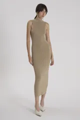 Vestido largo color beige, sin mangas y cuello alto. Tejido de punto ultradelgado y translúcido con lurex metalizado.