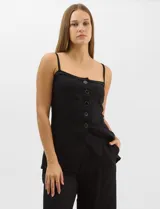 Conjunto monocromático compuesto por un top de breteles finos con escote recto y cierre frontal de botones, y un pantalón de tiro alto con pierna amplia y bolsillos laterales.