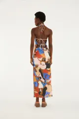 Falda larga fluida de tiro alto, confeccionada con tejido elástico y estampado multicolor de estilo artístico con figuras humanas. Cuenta con una abertura lateral en el bajo.