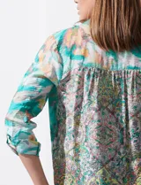 Blusa estampada de seda fría marca Figueroa & Flower. Tiene cuello a la base y escote en V, detalle de diferente estampa en hombros y espalda, apertura central con botones de nácar, mangas 3/4 regulables con presilla y botón, y terminación de ruedo con nudo.